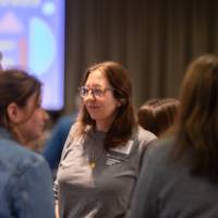 four people standing and talking